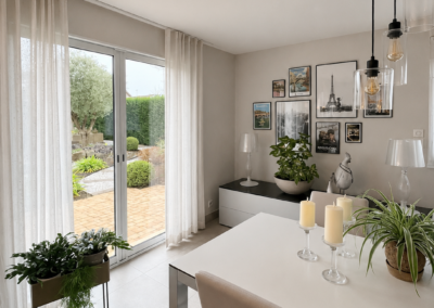 Photo avant travaux d'une salle à manger lumineuse avec table blanche et mur de cadres, projet de rénovation par Reflets & Design architecte d'intérieur dans le Morbihan