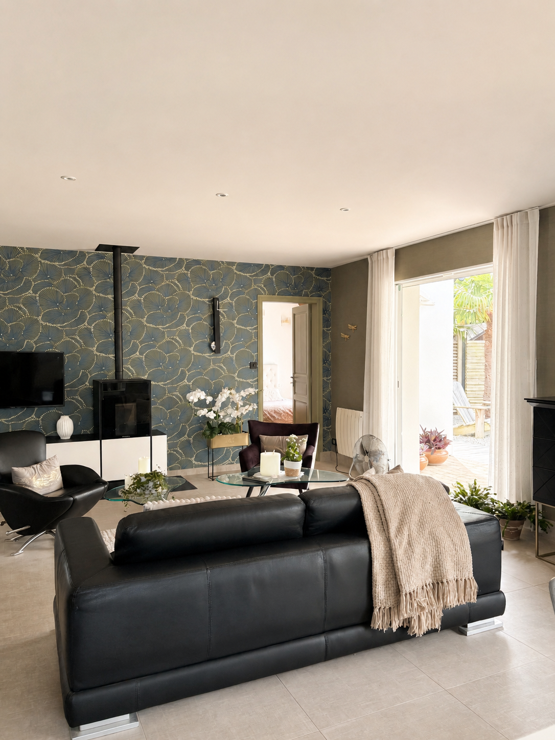 Salon rénové avec papier peint fleuri vert et poêle à bois, réalisé par Reflets & Design architecte d'intérieur dans le Morbihan